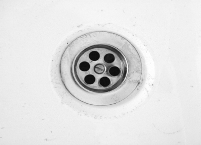 A photograph of a plughole to illustrate the poem "The Woman I Love" by Joshua Seigal, published in issue 29 of Neon